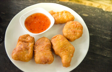 chicken nuggets with thai chicken sauce on white plate.
