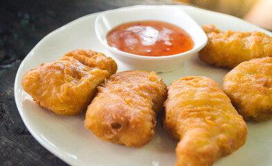chicken nuggets with thai chicken sauce on white plate.
