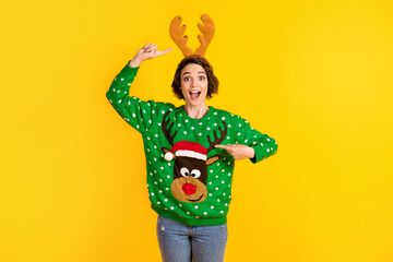 Shocked surprised crazy girl impressed x-mas christmas time celebration costume point finger antlers reindeer decor pullover headband isolated bright shine color background © deagreez