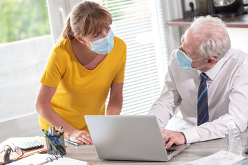 Businesspeople wearing protective medical mask in office during coronavirus outbreak