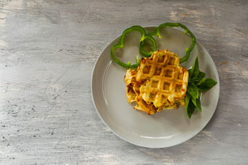 Salted waffles with herbs in a gray plate on a gray background.