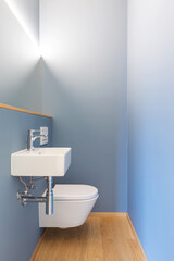 Front view of modern light blue bathroom with sink, mirror and led light