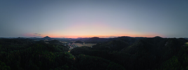 Luftaufnahme von einem Dorf nach Sonnenuntergang in hügeliger Landschaft, Jetrichovice Tschechische Republik