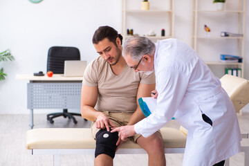 Obraz premium Experienced doctor traumatologist examining young male patient