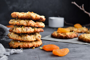 Oatmeal cookies. Homemade baking. Autumn concept of cookies with dried apricots and chocolate. Copy space. Dark background.