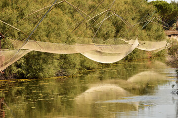 Reti di pescatori riflesse nel canale