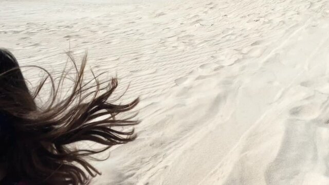 Two sisters having fun sliding down Lancelin sand dunes near Lancelin Western Australia