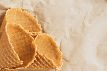 Empty ice cream cone. Empty waffle cups on crumpled craft paper.