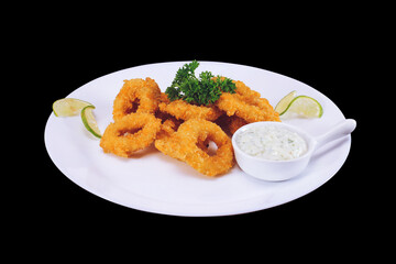 Fried squid or octopus (calamari) with sauce isolated against a background of dark. Top view.

