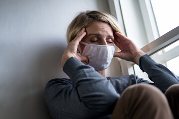 Woman indoors at home feeling stressed, mental health and coronavirus concept.