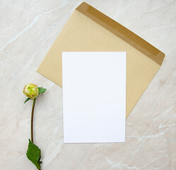 Greeting card, postcard, invitation image mock up on marble background with flowers. Flat lay for your design.