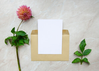 Greeting card, postcard, invitation image mock up on marble background with flowers. Flat lay for your design.