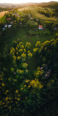 Fototapeta na wymiar Ländliches Dorf in hügeliger Landschaft bei Sonnenuntergang, Luftaufnahme