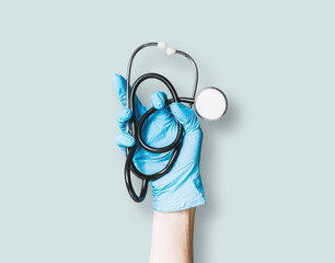 Hand holds a medical stethoscope. Medical and pharmaceutical concept. The doctor raises the stethoscope up, treating patients.