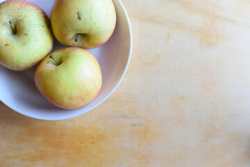 Fresh Apples in the Plate on Wooden Table