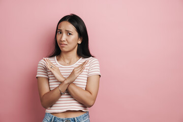 Obraz premium Beautiful confused asian woman showing stop gesture on camera