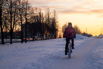 Fototapeta na wymiar A man rides a Bicycle through the snow in winter.