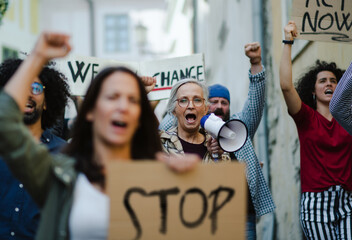 Group of people activists protesting on streets, strike and demonstration concept.