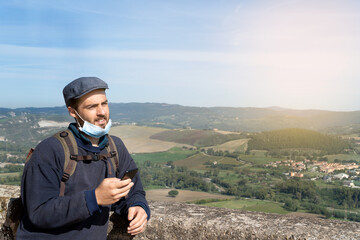 A man writing a message on his cell phone with a panoramic view