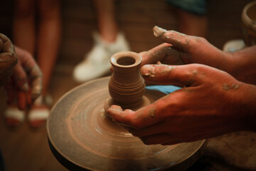 the image of the male hands of an artisan that sculpts from clay