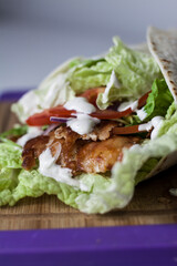Fresh kebab wrap with salad, red onion, tomatoes and sauce
