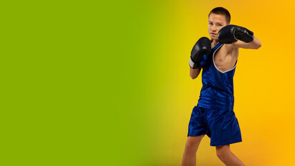 Winner. Teenage professional boxer training in action, motion isolated on gradient background in neon light. Kicking, boxing. Concept of sport, movement, energy and dynamic, healthy lifestyle. Flyer