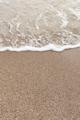 Different texture on the beach - water and sand, stones and pebbles, waves and splashes.