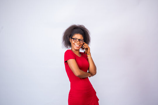 Smiling African Woman Wearing A Red Dress And Glasses Making A Phone Call