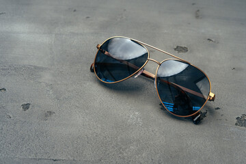 New dark aviator glasses on grey concrete background