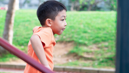 One sleepy and tired boy is playing  in the park during Summer season.A child at the playground during the nice weather day.Outdoor activity after lock down at the public play area.