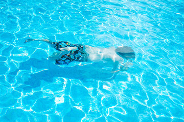 Young man enyoing the day at the swimming pool