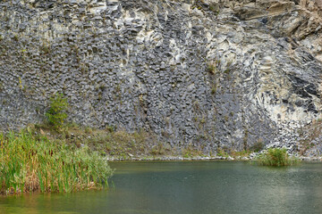 Lake in an ancient quarry with various types of rocks
