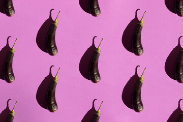 Fresh eggplant pattern isolated on purple background. Still life photography. Fruit pattern.