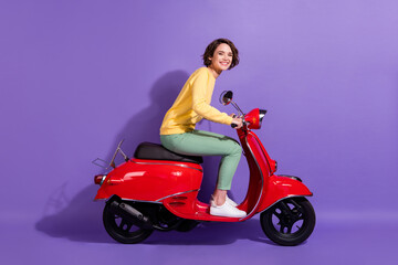 Fototapeta na wymiar Full length body size profile photo of brunette pretty student driving retro red moped smiling happily isolated on bright purple color background