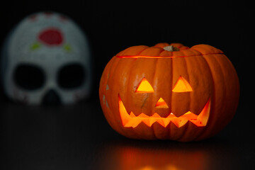  Halloween pumpkin and a scary mask on a black background.