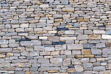textured wall of flat cobblestone in different colors and sizes