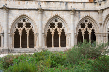 Fototapeta na wymiar Horizontal front view of gothic arches from the cloister garden of the Poblet Monastery, Tarragona, Spain, September 24, 2020