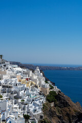 Fototapeta na wymiar Panoramic view of Thira town in Santorini island with old whitewashed houses and typical orthodox church, Greece Greek landscape on a sunny day. Portrait format