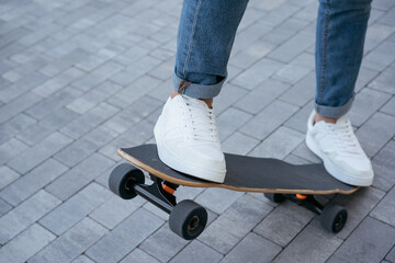 Man riding on a skateboard on urban street, practice skateboarding trick. Extreme sport, active lifestyle concept
