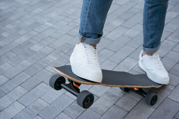 Fototapeta na wymiar Man riding on a skateboard on urban street, practice skateboarding trick. Extreme sport, active lifestyle concept