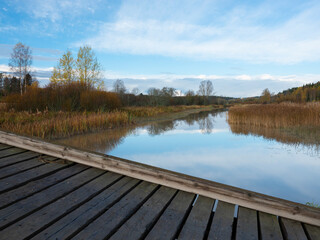 A beautiful rural agricultural scene casting reflections on the calm river surface.