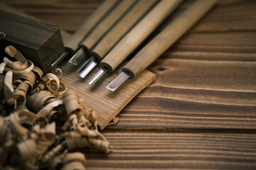 Close up view of a set of wood chisels for carving wood, sculpture tools on wooden background