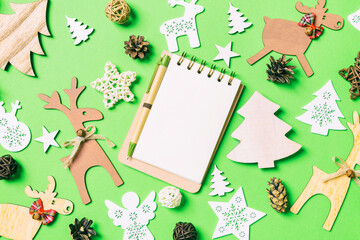 Christmas green background with holiday toys and decorations. Top view of notebook. Happy New Year concept