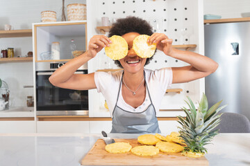 Woman with two pineapple slices in front of her eyes