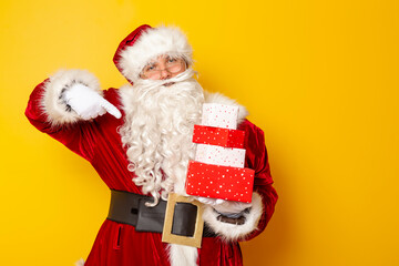 Santa Claus holding bunch of Christmas presents