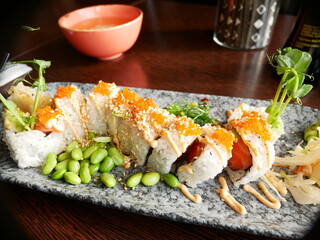 Sushi lunch, california roll with salmon, rice, white roe, seawseed, chili mayonnaise and edamame beans