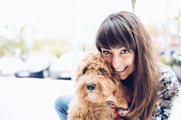 Attractive Caucasian girl poses with her lovely puppy. Pets love concept.