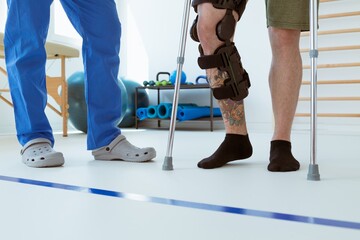 Injured patient learns to walk on crutches in medical office