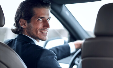 man sitting behind the wheel of a car