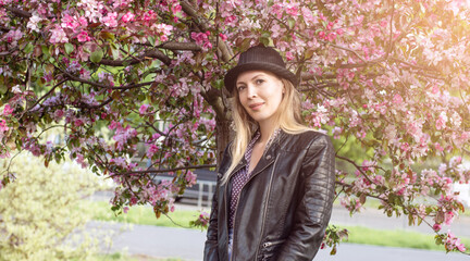 Portrait of a beautiful woman among spring foliage and flowers